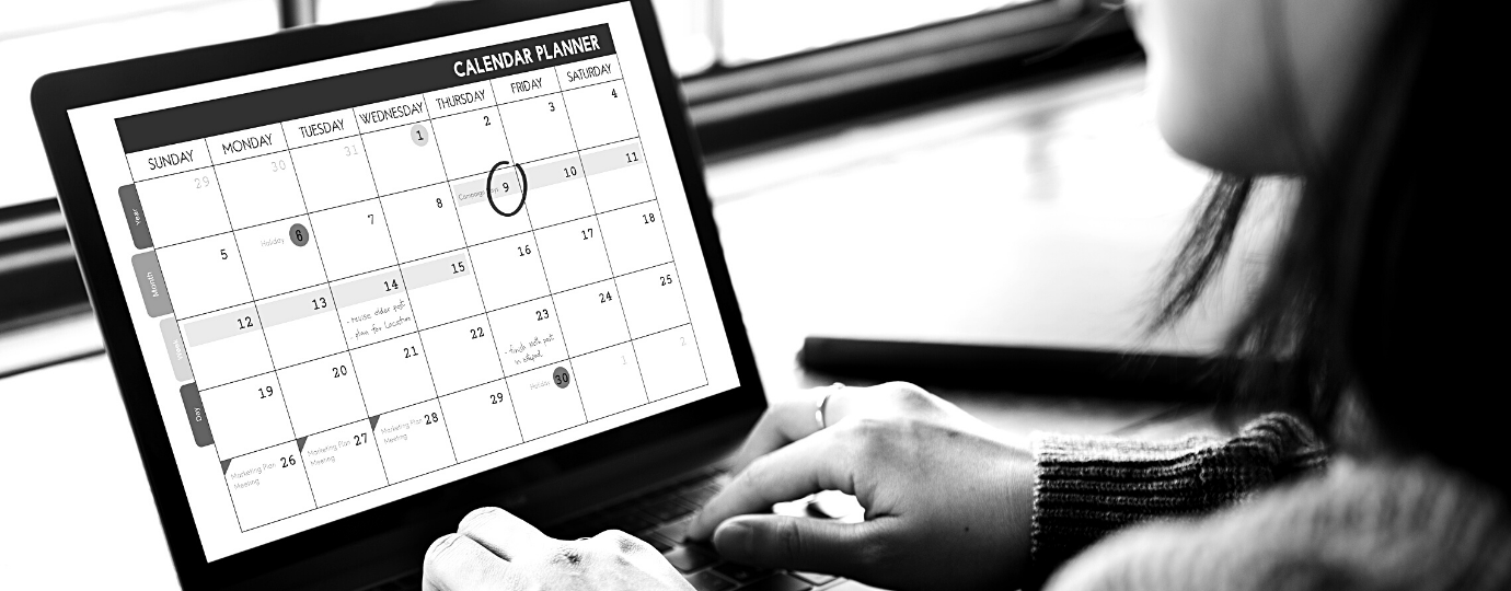 a woman looks at her calendar on her laptop